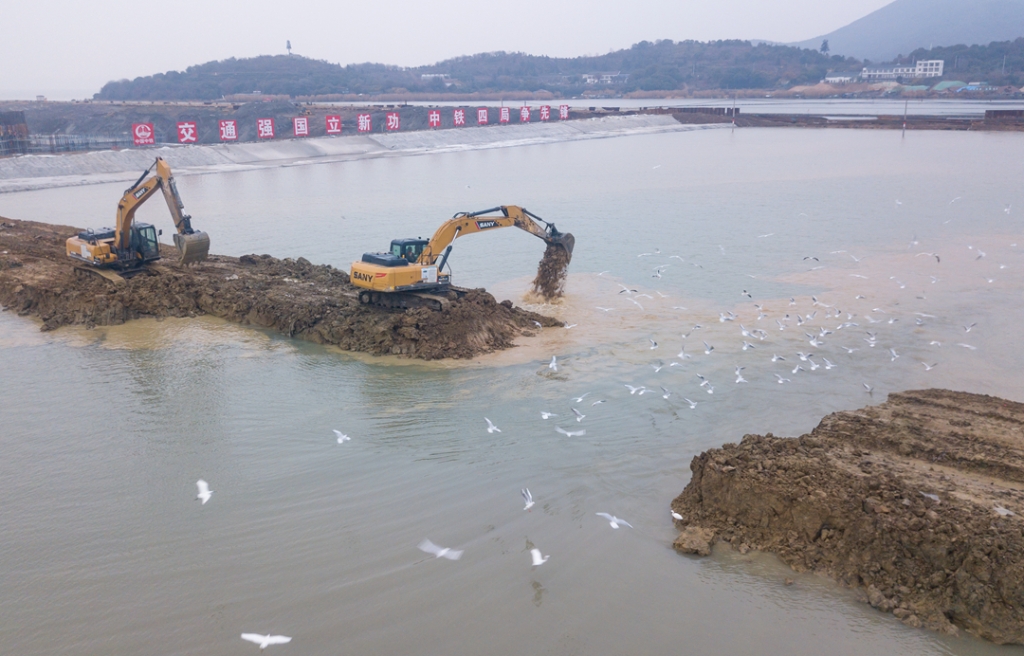 2019年12月23日，鳥群從陸島轉(zhuǎn)換圍堰回水施工現(xiàn)場飛過。